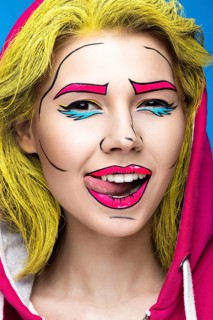 Photo of surprised young woman with professional comic pop art make-up. Creative beauty style. Photos shot in studio
