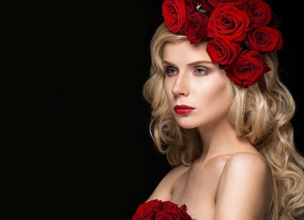 Beautiful blond girl in a dress and hat with roses