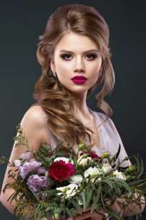 Portrait of a beautiful woman in the image of the bride with flowers in her hands. Picture taken in the studio. Beauty face and Hairstyle