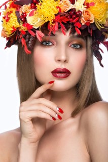 Beautiful girl with bright autumn leaves. Beauty face. Picture taken in the studio on a white background