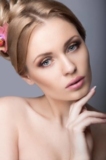 Portrait of a beautiful woman in the image of the bride with flowers in her hair. Picture taken in the studio on a black background