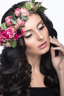Portrait of a beautiful woman in the image of the bride with flowers in her hair. Picture taken in the studio on a black background