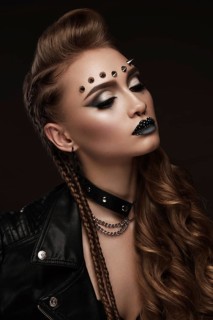 Portrait of a beautiful woman in a rock style image with creative makeup and hairstyle