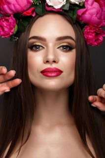 Beautiful girl with bright make up and flowers on her head. Beauty face. Photos shot in studio