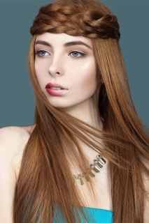 Beautiful red-haired girl with a pigtail hair and unusual lips. Portrait shot in the studio on a blue background