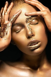Beautyful girl with gold glitter on her face.Art image beauty face. Picture taken in the studio on a black background