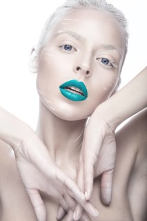 Beautiful girl in the image of albino with blue lips and white eyes. Art beauty face. Picture taken in the studio on a white background