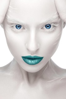 Beautiful girl in the image of albino with blue lips and white eyes. Art beauty face. Picture taken in the studio on a white background