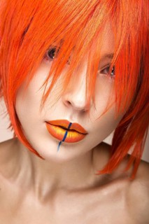 Beautiful girl in an orange wig cosplay style with bright creative lips. Art beauty image. Portrait shot in the studio