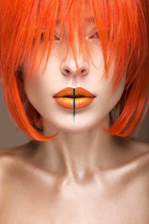 Beautiful girl in an orange wig cosplay style with bright creative lips. Art beauty image. Portrait shot in the studio