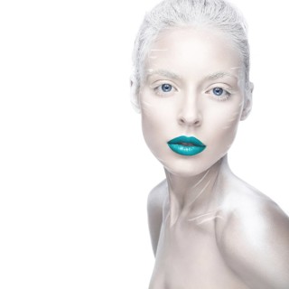 Beautiful girl in the image of albino with blue lips and white eyes. Art beauty face. Picture taken in the studio on a white background