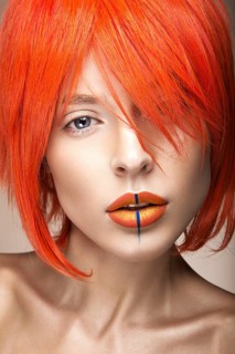 Beautiful girl in an orange wig cosplay style with bright creative lips. Art beauty image. Portrait shot in the studio