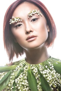Fashion beautiful girl oriental type with delicate natural make-up and flowers. Beauty face. Picture taken in the studio on a white background
