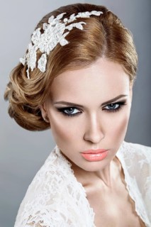 Portrait of a beautiful blonde woman in the image of the bride with flowers in her hair. Picture taken in the studio on a blue background