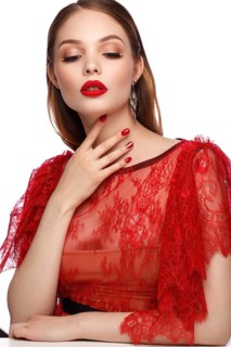 Beautiful girl in red dress with classic make-up and red manicure. Beauty face. Photo taken in the studio
