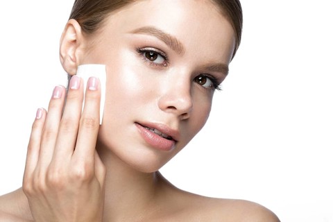 Beautiful young girl with wipes for removing makeup and French manicure. Beauty face. Picture taken in the studio on a white background