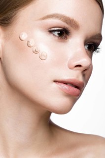 Beautiful young girl with tone cream on her skin. Beauty face. Picture taken in the studio on a white background
