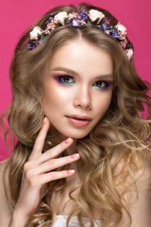 Portrait of a beautiful blond girl in image of the bride with purple flowers on her head. Beauty face. Photo shot in the Studio