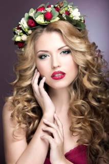 Portrait of a beautiful woman in the image of the bride with flowers in her hair. Picture taken in the studio on a black background