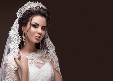 Beautiful brunette girl in the image of the Arab bride in a wedding dress and a crown on her head. Beauty face. Picture taken in the studio