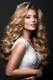 Beautiful blonde bride in wedding image with curls and crown. Beauty face. Picture taken in the studio