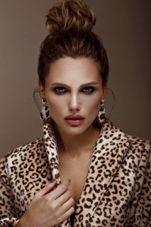 Beautiful sexy woman in a leopard coat and earrings