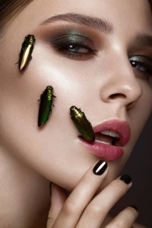 Portrait of beautiful girl with colorful make-up and cockroaches. Beauty face. Photo taken in the studio