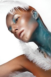 Portrait of a girl with gold and blue creative art make-up. Photo taken in the studio