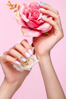 Beautiful pink and blue manicure with crystals on female hand. Close-up. Picture taken in the studio