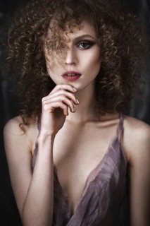 Beautiful girl with curly hair in lingerie with large flower. The beauty of the face. Photos shot in studio