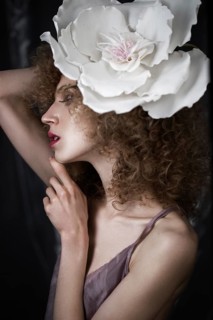 Beautiful girl with curly hair in lingerie with large flower. The beauty of the face. Photos shot in studio