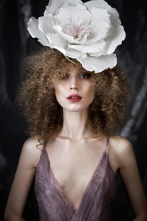 Beautiful girl with curly hair in lingerie with large flower. The beauty of the face. Photos shot in studio
