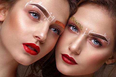 Two girls are twin sisters with an unusual eyebrow makeup. Beauty face. Photo taken in the studio