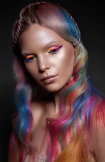 Beautiful girl with multi-colored hair and creative make-up and hairstyle. Beauty face. Photo taken in the studio