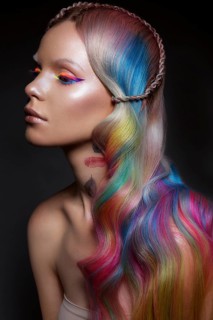 Beautiful girl with multi-colored hair and creative make-up and hairstyle. Beauty face. Photo taken in the studio