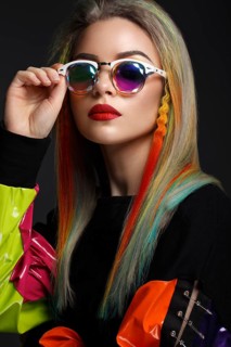 Beautiful girl with multi-colored hair and creative make-up and hairstyle. Beauty face. Photo taken in the studio