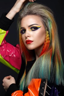 Beautiful girl with multi-colored hair and creative make-up and hairstyle. Beauty face. Photo taken in the studio