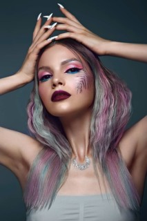 Beautiful girl with multi-colored hair and creative make up and hairstyle. Beauty face. Photo taken in the studio