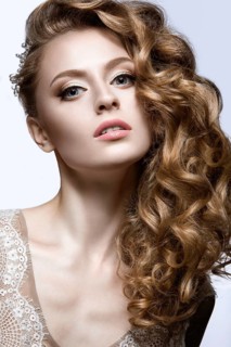 Portrait of a beautiful woman in the image of the bride with jewelry in her hair. Picture taken in the studio on a black background