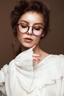 Beautiful girl in stylish clothes with glasses for vision. Beauty face. Photo taken in the studio