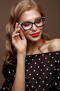 Beautiful girl in stylish clothes with glasses for vision and red sexy lips. Beauty face. Photo taken in the studio