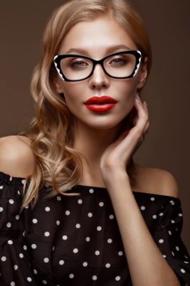 Beautiful girl in stylish clothes with glasses for vision and red sexy lips. Beauty face. Photo taken in the studio