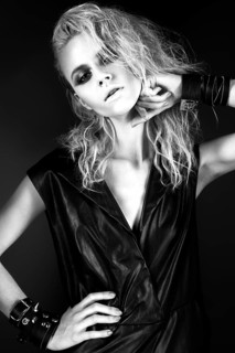 Daring girl model in black leather dress in the style of rock