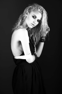 Daring girl model in black silk dress in the style of rock