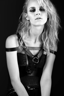 Daring girl model in black leather dress in the style of rock