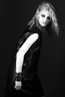 Daring girl model in black leather dress in the style of rock