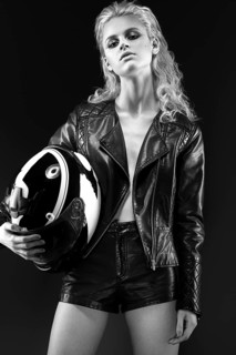 Daring girl model in black leather dress in the style of a rock on a naked body