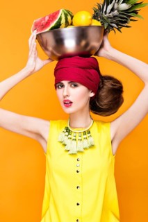 Beautiful fashionable woman an unusual hairstyle in bright clothes and colorful accessories. Cuban style. Picture taken in the studio on a bright background