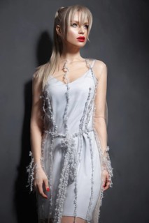 Beautiful girl in designer fashionable transparent clothes posing in studio. Beauty of face and body