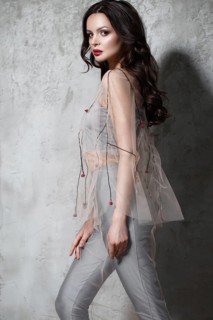 Beautiful girl in designer fashionable transparent clothes posing in studio. Beauty of face and body
